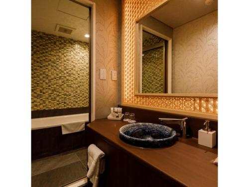 ein Bad mit einem Waschbecken und einem Spiegel in der Unterkunft Hotel Rashiku Kanazawa - Vacation STAY 49686v in Kanazawa