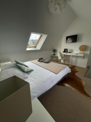 Schlafzimmer mit einem großen Bett und einem Fenster in der Unterkunft L'Annexe Amiens in Amiens