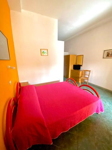 a red bed with two chairs in a room at Residence Hotel Felix in Ricadi