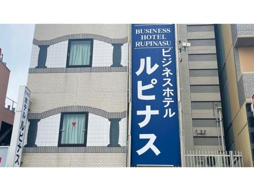 a building with a sign on the side of it at Business Hotel Lupinus - Vacation STAY 55803v in Takamatsu