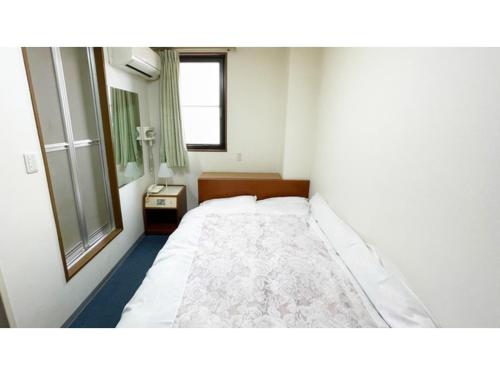 - une chambre avec un grand lit et une fenêtre dans l'établissement Business Hotel Lupinus - Vacation STAY 55814v, à Takamatsu