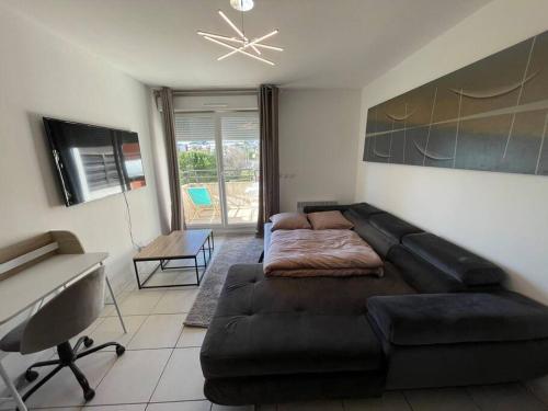 ein Wohnzimmer mit einem Sofa und einem Schreibtisch in der Unterkunft T2 Cosy Montpellier in Montpellier