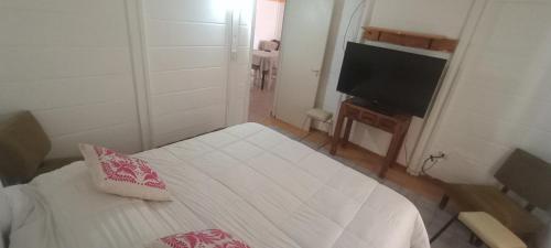 a small room with a bed and a flat screen tv at Alojamiento beba in Rada Tilly