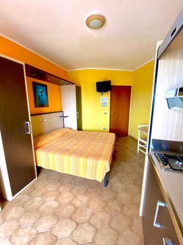 a bedroom with a bed and yellow walls at Residence Hotel Felix in Ricadi