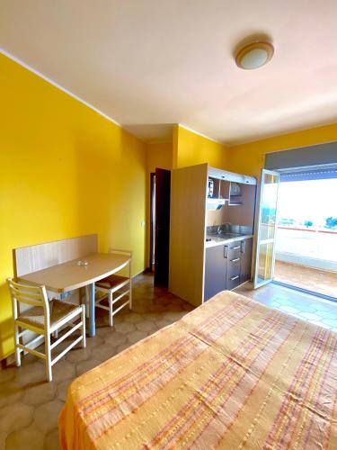 a bedroom with a bed and a table and a kitchen at Residence Hotel Felix in Ricadi