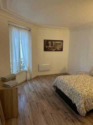 1 dormitorio con cama y ventana grande en Cosy appartement entre Paris et Disneyland, en Le Perreux-Sur-Marne