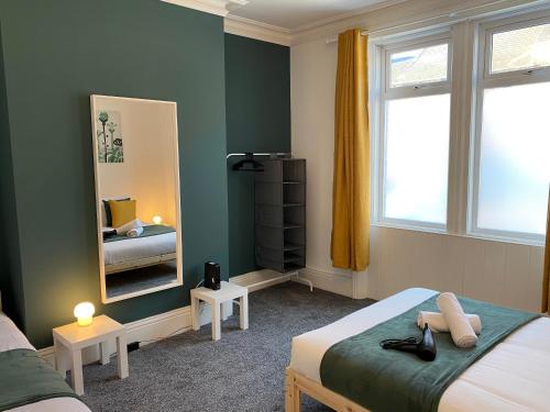 a bedroom with two beds and a mirror at Kitchener - Wonderful 2-Bedroom Apt Sleeps 5 Free Parking Free WiFi in Gateshead