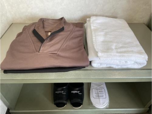 uno scaffale con giacca, borsa e scarpe di Hotel Areaone Hiroshima Wing - Vacation STAY 62250v a Higashihiroshima