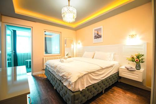 una camera con un grande letto e un lampadario a braccio di Cihangir VAV Suites a Istanbul