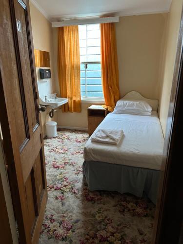 Habitación de hotel con cama y ventana en Club Hotel Pahiatua, en Pahiatua