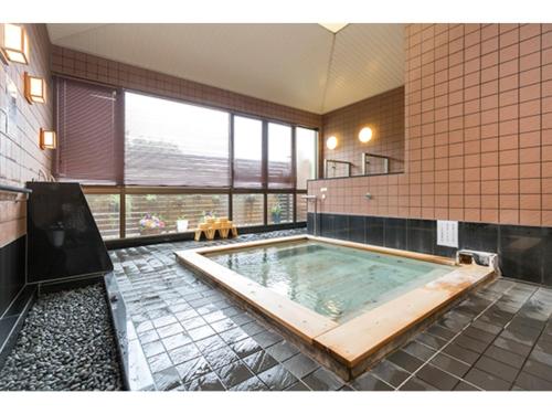 ein großes Bad mit einer großen Badewanne in einem Zimmer in der Unterkunft IyashinoYado Akariya - Vacation STAY 74775v in Kanayama