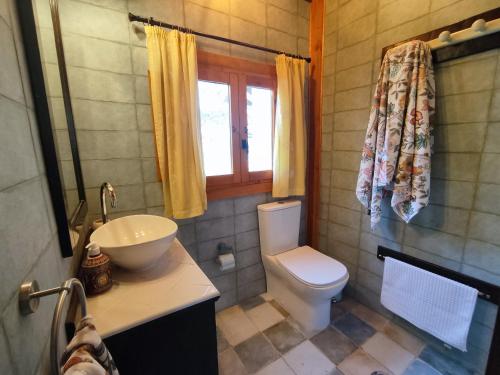 baño con aseo y lavabo y ventana en Apartamento El Grifo en Carmona
