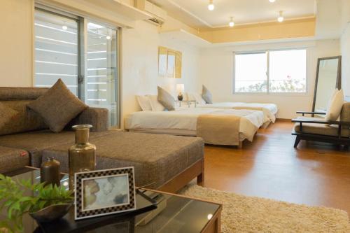 uma sala de estar com duas camas e um sofá em Seacore Villa - Vacation STAY 14248 em Ishigaki
