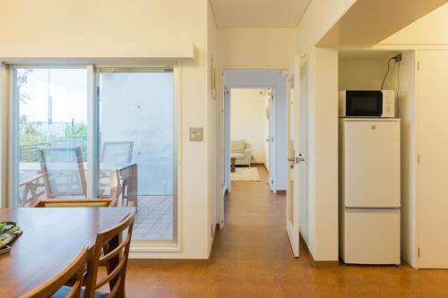 uma cozinha e sala de jantar com uma mesa e um micro-ondas em Seacore Villa - Vacation STAY 14248 em Ishigaki