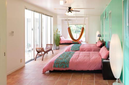 - une chambre avec un grand lit et un couvre-lit rose dans l'établissement MILLEFY's HOUSE - Vacation STAY 14247, à Ishigaki