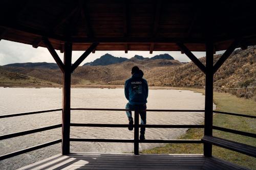 a man standing on a fence looking at the water at Viajero Quito Hostel in Quito