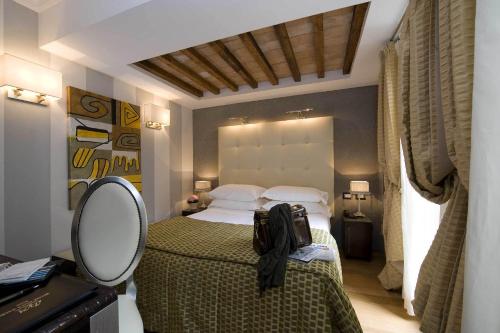 a bedroom with a large bed and a mirror at Duca d'Alba Hotel - Chateaux & Hotels Collection in Rome