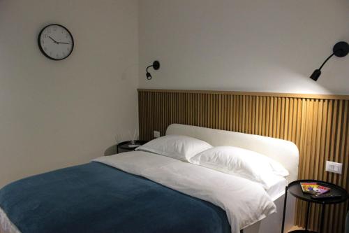 1 dormitorio con 1 cama y reloj en la pared en Studio in Tirana en Tirana
