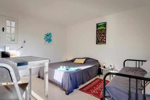 a bedroom with a bed and a table and a tableablish at Le jardin de Neptune in Rayol-Canadel-sur-Mer