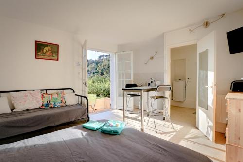 une chambre avec un lit et une table et une cuisine dans l'établissement Le jardin de Neptune, à Rayol-Canadel-sur-Mer
