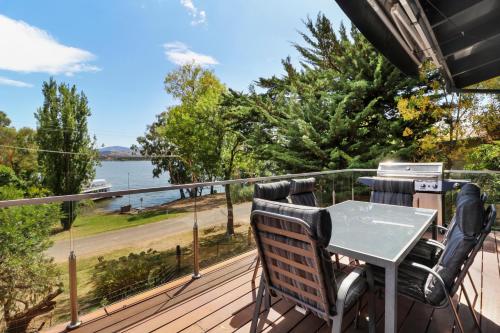 a table and chairs on a deck with a view of the water at Dawn Retreat in Bonnie Doon