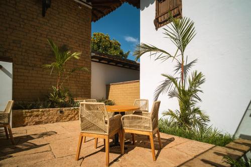 a patio with a table and chairs and a palm tree at Hotel Casa Alcestre in Villa de Leyva