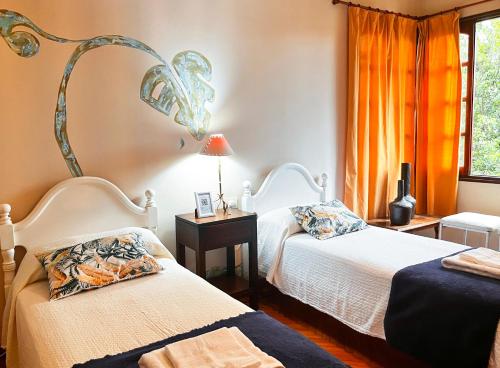 1 dormitorio con 2 camas y lámpara en Calchaquíes Home Hostel en San Salvador de Jujuy