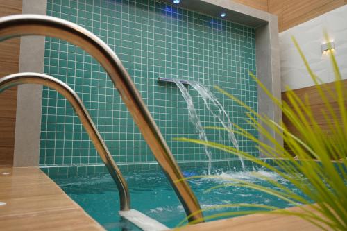 baño con piscina con azulejos azules en Exótico Prime Motel en Ribeirão Preto