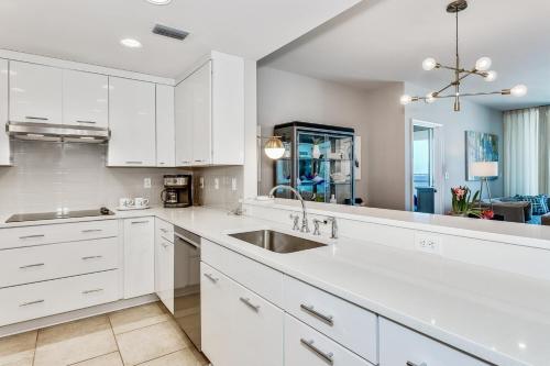 a kitchen with white cabinets and a sink at Portofino Island Resort Tower 2-703 in Pensacola Beach