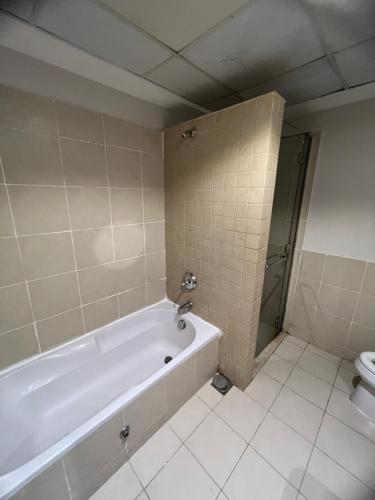 uma casa de banho com banheira e WC em بِيُوتات الرفآه - اطلالة بحرية ساحرة em King Abdullah Economic City