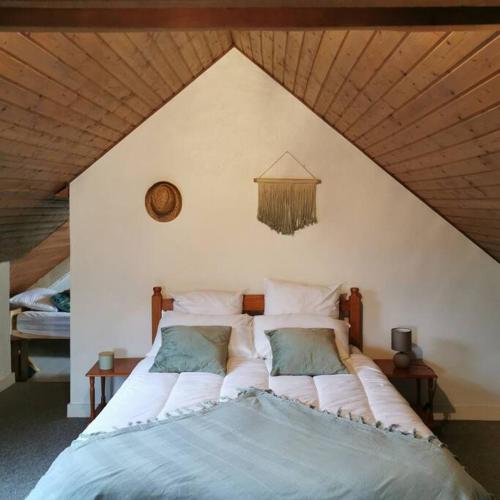 un lit avec deux oreillers dessus dans une chambre dans l'établissement Gîte du Placello, piscine jacuzzi et sauna, à Quistinic