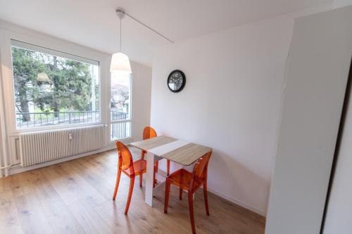 een eetkamer met een tafel en stoelen en een raam bij LE DAUPHIN - Place parking privée gratuit - WIFI et TV in Saint-Étienne