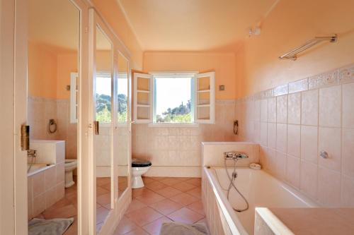 e bagno con vasca, servizi igienici e lavandino. di Les Iles D'Or a Le Rayol-Canadel-sur-Mer