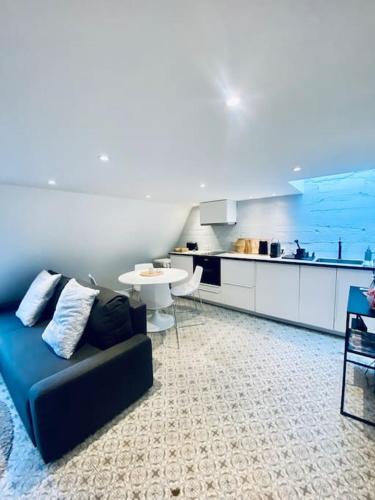 un salon avec un canapé bleu et une cuisine dans l'établissement *Astoria 6* Appart Cosy en plein centre, à Vichy