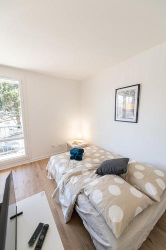 une chambre blanche avec un grand lit et un bureau dans l'établissement LE DAUPHIN - Place parking privée gratuit - WIFI et TV, à Saint-Étienne