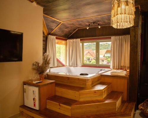a bath tub in a room with a window at Pousada Rosa Maria in Erechim