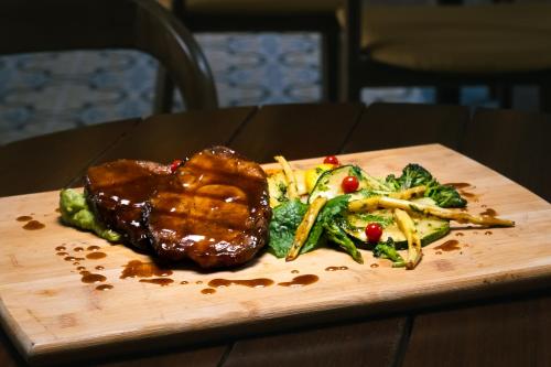 a plate of food with meat and vegetables on a table at Hotel Casa Alcestre in Villa de Leyva