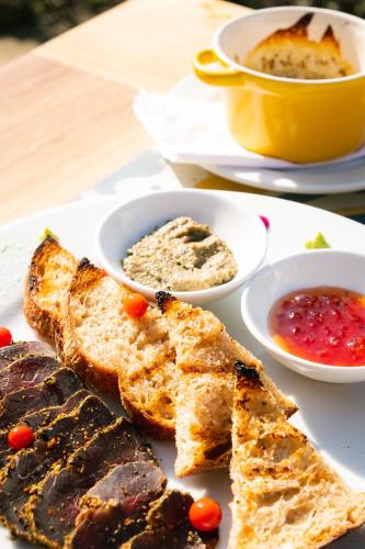 a plate of food with bread and two bowls of soup at Hotel Casa Alcestre in Villa de Leyva