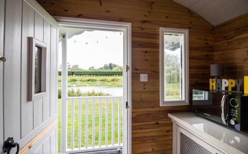 a kitchen with a door leading to a balcony at Wildflower Meadow Cabins in Whitington