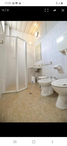 a bathroom with two toilets and a glass shower at Hotel Residence Villa Lily in Cesenatico