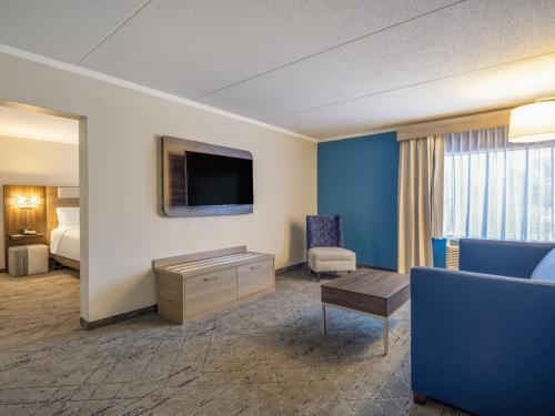 a hotel room with a bed and a tv at Holiday Inn Express & Suites Greensboro - I-40 atWendover by IHG in Greensboro