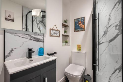 a bathroom with a sink and a toilet and a shower at The Honeycomb Residence in Cheltenham