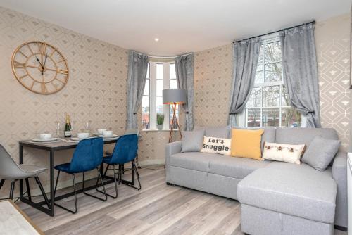 a living room with a couch and a table with chairs at The Honeycomb Residence by Fortuna Property Portfolio in Cheltenham