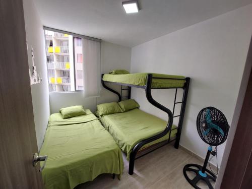 a small room with two bunk beds and a fan at Apartamento Barlovento Piso 5 Vista a la Piscina in Girardot