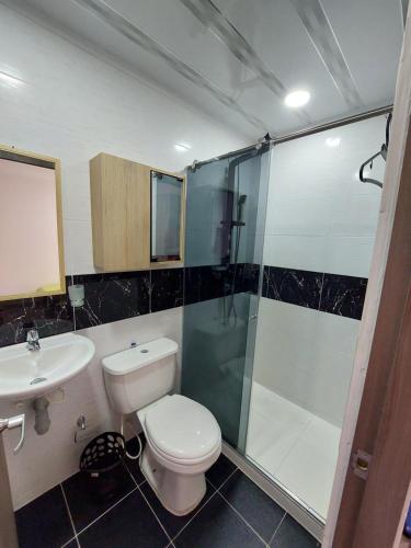 La salle de bains est pourvue de toilettes, d'une douche et d'un lavabo. dans l'établissement Apartamento Barlovento Piso 5 Vista a la Piscina, à Girardot