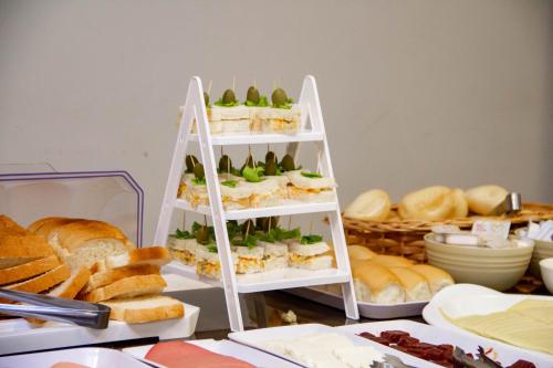 a shelf of sandwiches and bread on a table at HOTEL DOMHOF in Blumenau