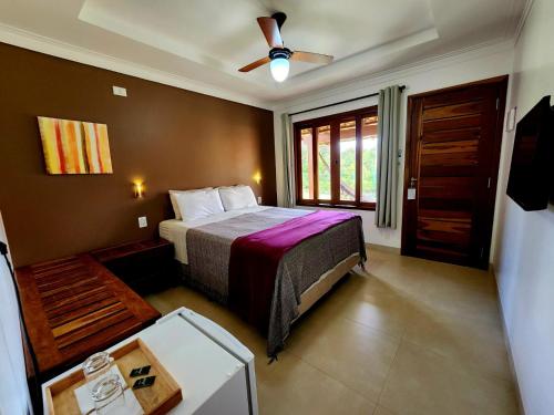 a bedroom with a bed and a ceiling fan at Pousada Camarás in Alto Paraíso de Goiás
