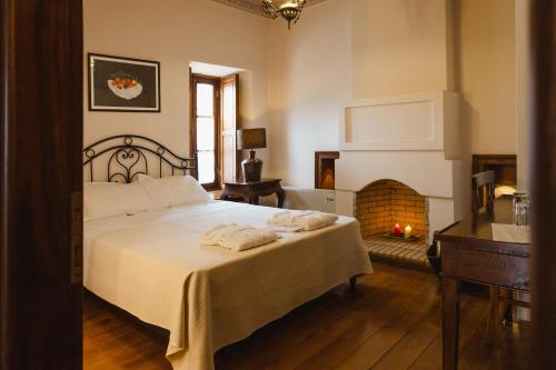 ein Schlafzimmer mit einem Bett und einem Kamin in der Unterkunft Ξενώνας Αρχοντικό Ελληνοπύργου in Ellinopyrgos