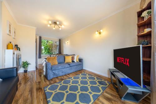 a living room with a blue couch and a tv at Pierocks Carver Entire house, Hot tub & WIFI in High Wycombe