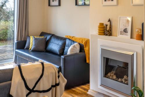 a living room with a blue couch and a fireplace at Pierocks Carver Entire house, Hot tub & WIFI in High Wycombe